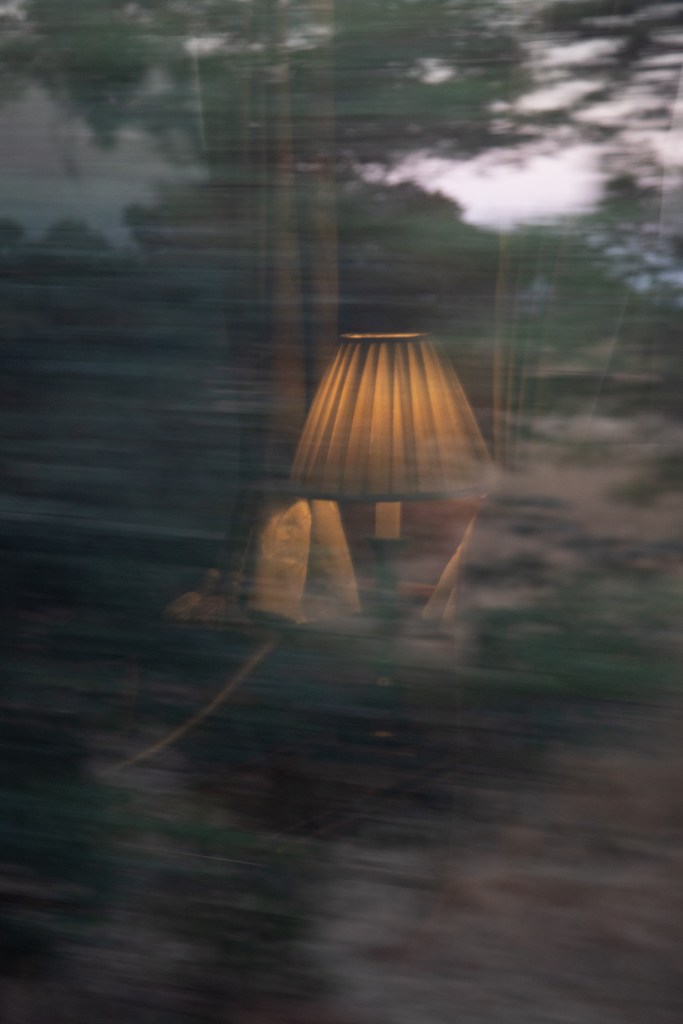 A lamp reflected in the window of a moving Rovos Rail train in South Africa